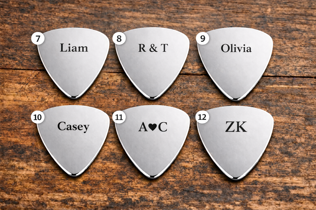 Set of six silver guitar picks with names engraved on a wooden surface