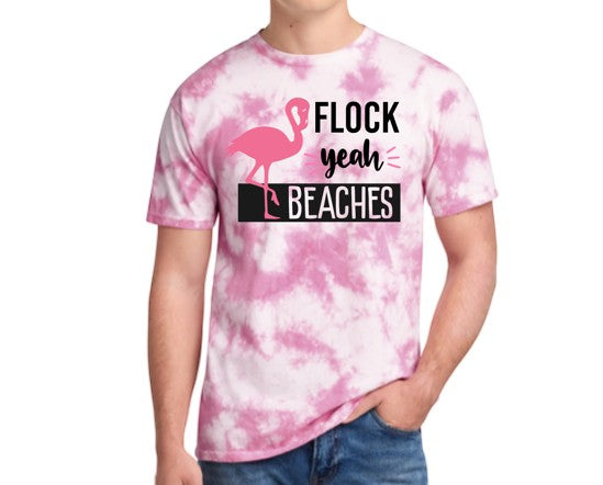 Black Flag Promotions pink and white tie-dye t-shirt with a flamingo graphic and Flock Yeah Beaches slogan on a man.