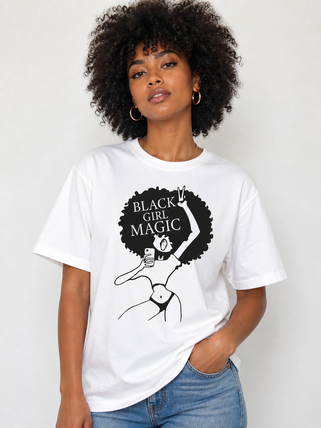 Person wearing a white t-shirt with 'Black Girl Magic' graphic design on a plain background