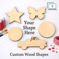 Wooden shapes including a star, butterfly, truck, and circles on a white background with paint bottles and brushes.