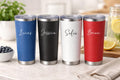 Four custom insulated tumblers in blue, black, white, and red with names engraved on a kitchen counter. Upload your logo. Perfect for every day use or a gift. Company business gifts. Employee appreciation gifts. 