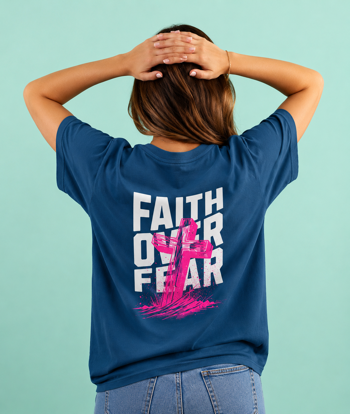Person wearing a blue t-shirt with 'Faith Over Fear' design on the back against a light blue background