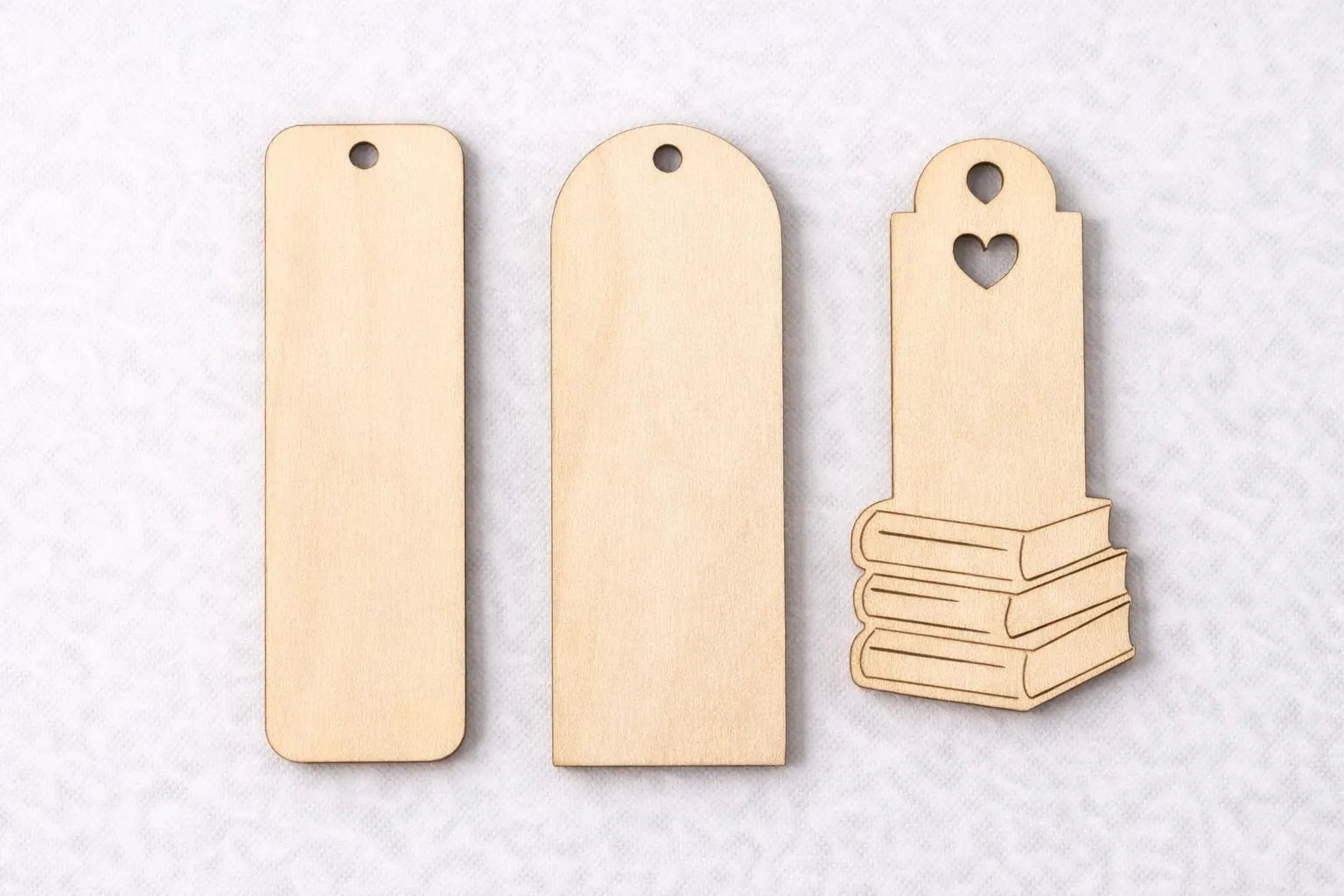 Three wooden bookmarks on a light gray background