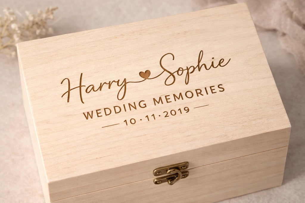Wooden box engraved with 'Harry & Sophie Wedding Memories 10.11.2019' on a neutral background
